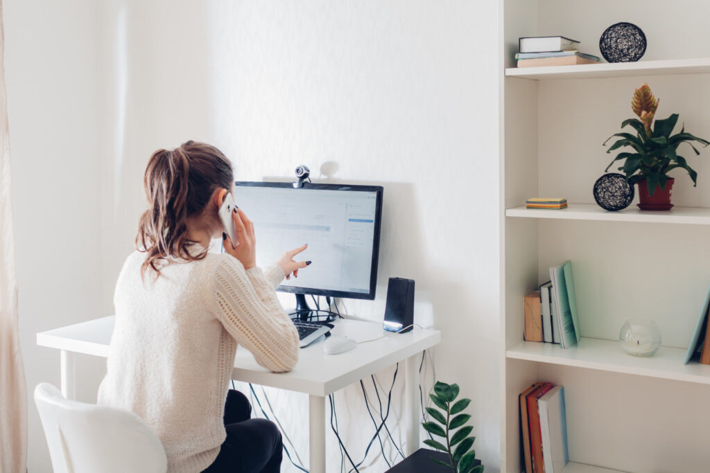 Woman working from home on phone and computer